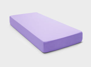 Stretchy and easy-care fitted sheet in light purple colour by It-Fits, perfectly fitted on a mattress with deep pockets against a neutral background.