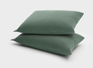 It-Fits soft cotton jersey pillow slips in sage green, stacked on two pillows, 2 pack, creating a calming, restful night with breathable, temperature-regulating fabric.